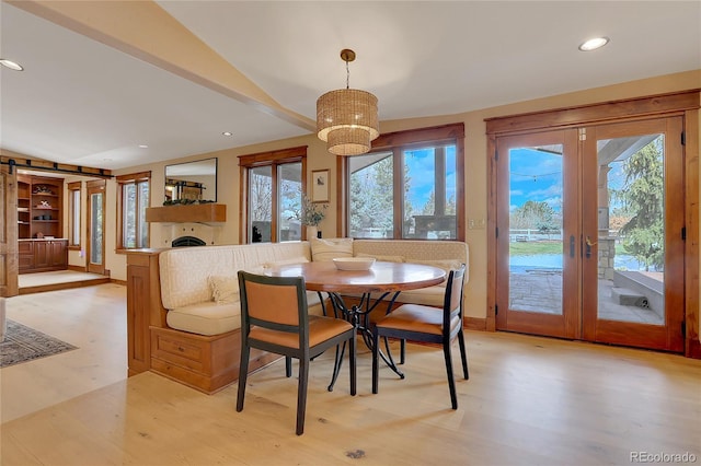 dining room with french doors, light hardwood / wood-style floors, and lofted ceiling