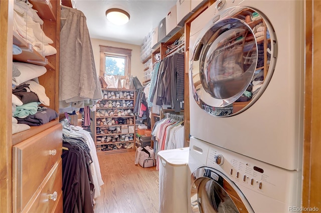 washroom with light wood-type flooring and stacked washer and clothes dryer