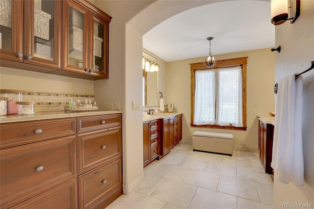 bathroom featuring tile patterned flooring, vanity, and tasteful backsplash