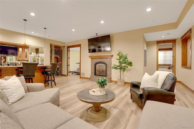 living room featuring light wood-type flooring and indoor bar