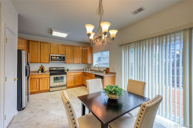 7345 S Nucla St, Aurora, CO 80016 - kitchen featuring stainless steel appliances, light countertops, a chandelier, and hanging light fixtures