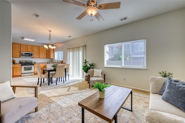 7345 S Nucla St, Aurora, CO 80016 - living area with a chandelier, light carpet, and a ceiling fan