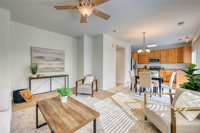 7345 S Nucla St, Aurora, CO 80016 - living area with light carpet, a chandelier, and a ceiling fan