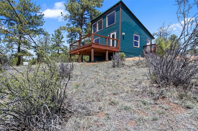 rear view of property featuring a wooden deck