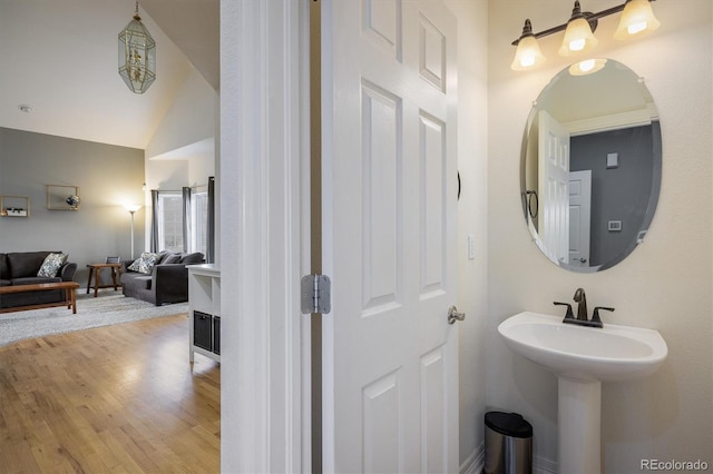 bathroom with hardwood / wood-style floors and lofted ceiling