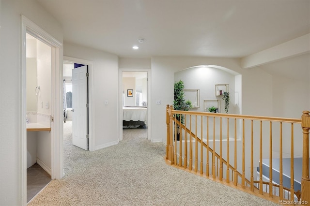 hall with light colored carpet and vaulted ceiling