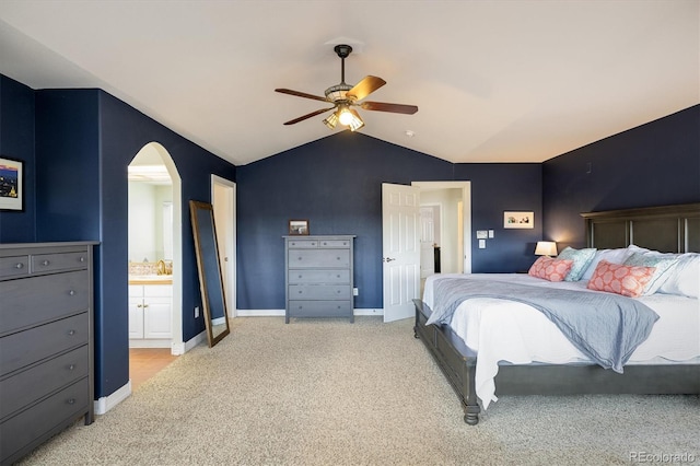 carpeted bedroom featuring ceiling fan, ensuite bath, and vaulted ceiling