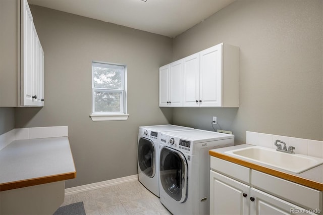 laundry area featuring sink, cabinets, and independent washer and dryer