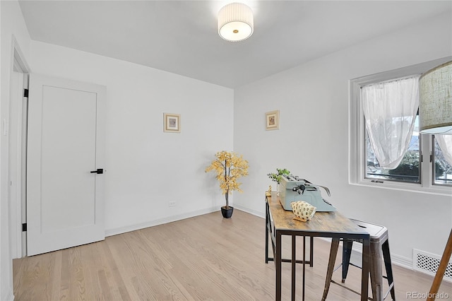 office area with visible vents, wood finished floors, and baseboards