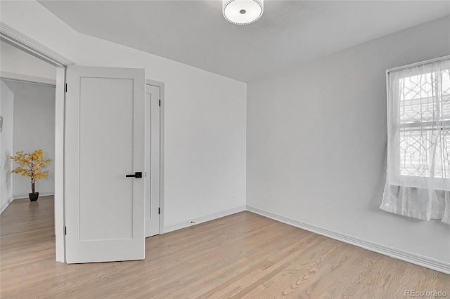 empty room featuring baseboards and light wood-type flooring