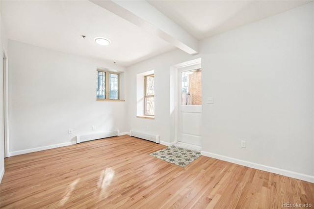 foyer entrance with wood finished floors, a baseboard heating unit, and baseboards