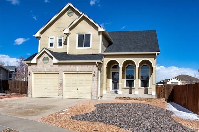 view of front facade featuring driveway, a garage, fence, and brick siding