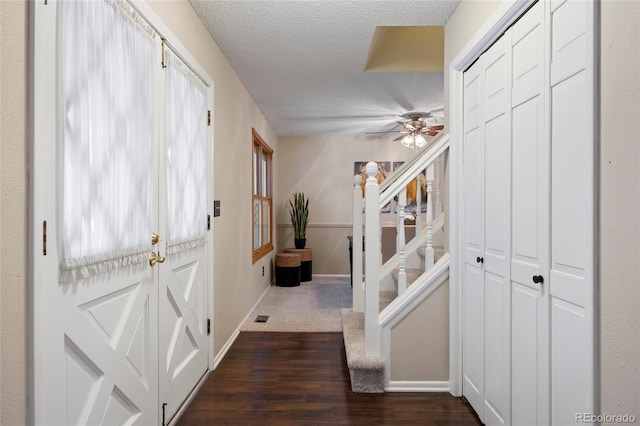 hallway featuring dark wood-type flooring and a textured ceiling