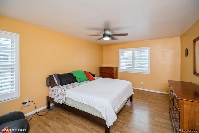 bedroom with baseboards, a ceiling fan, and wood finished floors