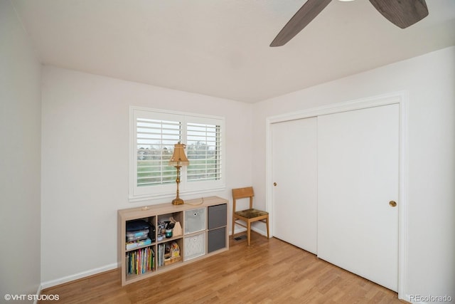 bedroom featuring baseboards, ceiling fan, a closet, and light wood finished floors