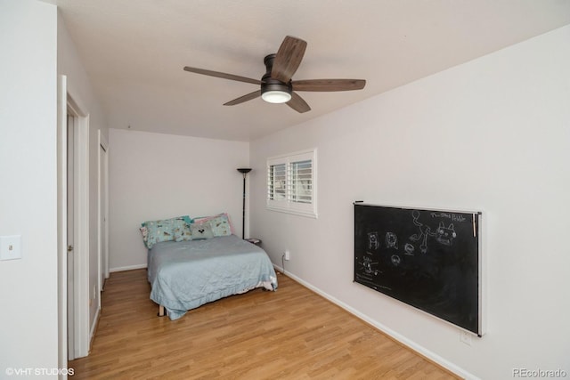 bedroom with baseboards, ceiling fan, and wood finished floors