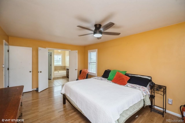 bedroom featuring ceiling fan, ensuite bath, and wood finished floors