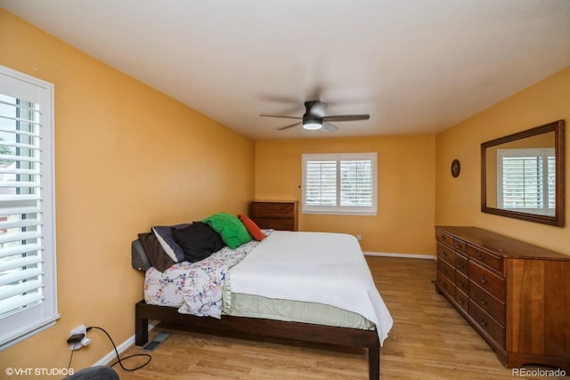 bedroom with baseboards, ceiling fan, and light wood-type flooring