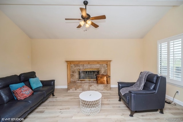 living room featuring baseboards, ceiling fan, vaulted ceiling, and wood finished floors