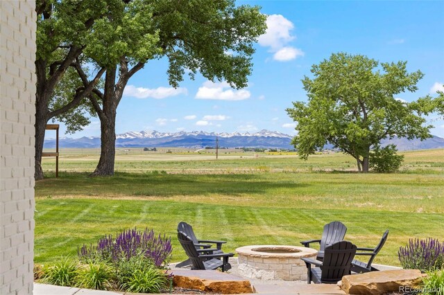 view of yard featuring a mountain view, a fire pit, and a rural view