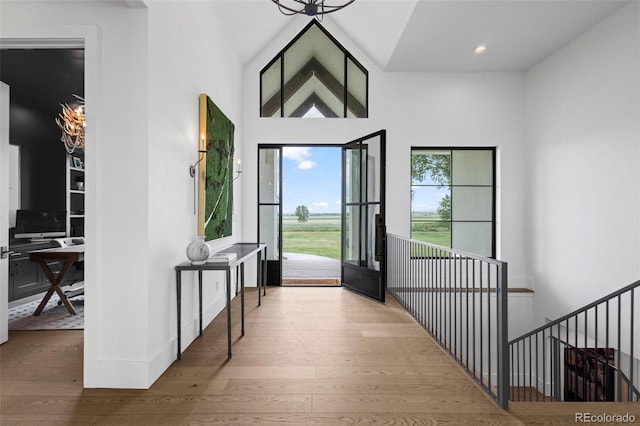 foyer entrance with a towering ceiling and light hardwood / wood-style flooring