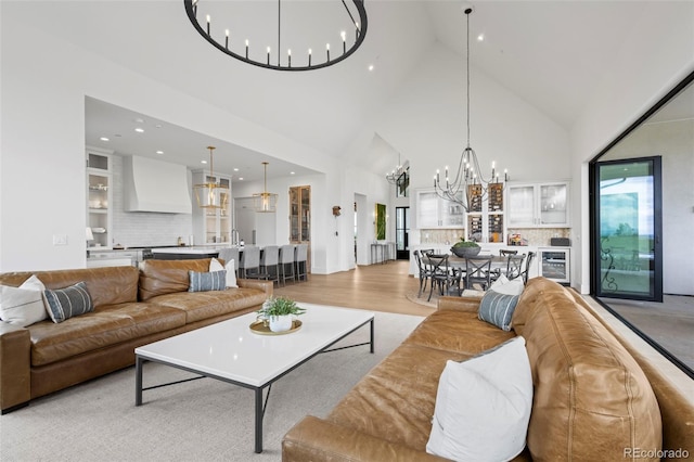 living room featuring light hardwood / wood-style floors, high vaulted ceiling, plenty of natural light, and wine cooler