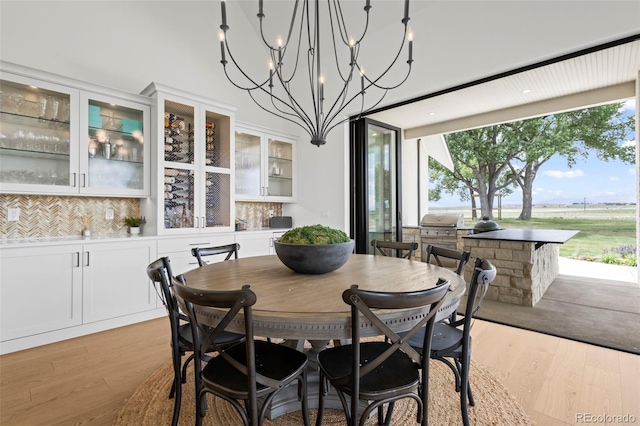 dining room with a healthy amount of sunlight, an inviting chandelier, and light hardwood / wood-style flooring