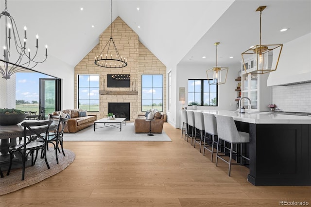 interior space with a stone fireplace, plenty of natural light, and light wood-type flooring