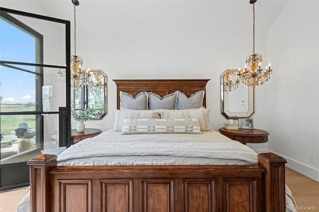 bedroom with a notable chandelier, multiple windows, and light hardwood / wood-style flooring