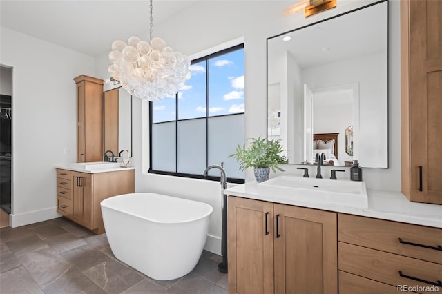 bathroom with tile flooring, an inviting chandelier, a bath to relax in, and double sink vanity