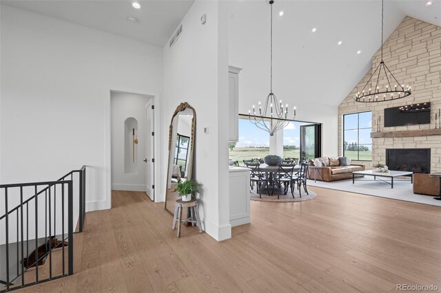 interior space featuring high vaulted ceiling, a chandelier, and light wood-type flooring