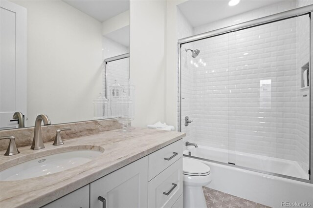 full bathroom with large vanity, tile flooring, combined bath / shower with glass door, and toilet