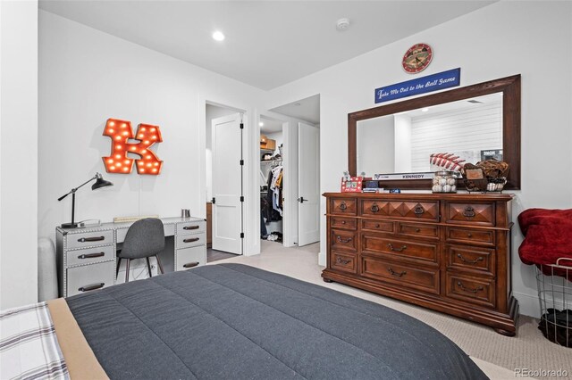 carpeted bedroom with a closet and a walk in closet