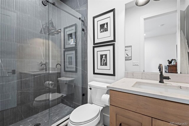 bathroom with a shower with shower door, toilet, and vanity with extensive cabinet space