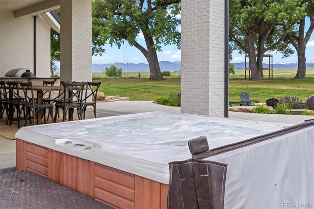 view of terrace with a mountain view and a hot tub