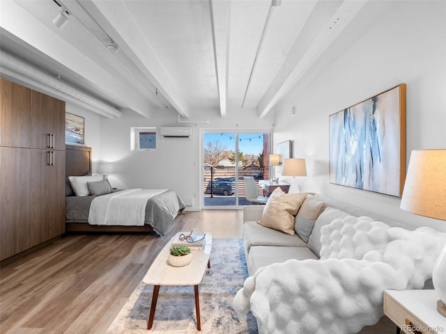 bedroom featuring light wood-style flooring, rail lighting, access to outside, an AC wall unit, and beam ceiling