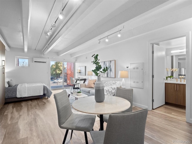 dining space with baseboards, rail lighting, an AC wall unit, light wood-style floors, and beam ceiling