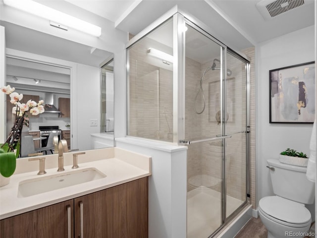 bathroom with visible vents, a shower stall, toilet, and vanity