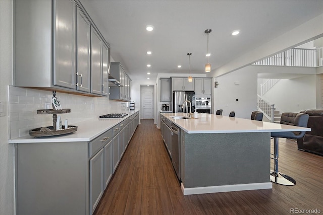 kitchen featuring hanging light fixtures, sink, backsplash, a breakfast bar area, and stainless steel appliances