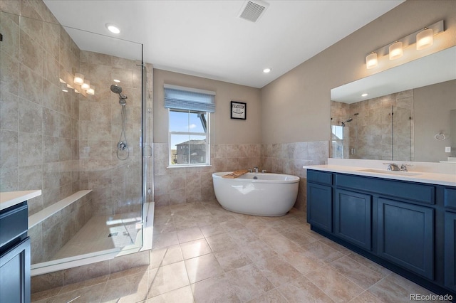 bathroom featuring tile walls, tile patterned floors, vanity, and separate shower and tub