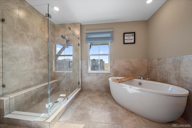 bathroom featuring tile walls and separate shower and tub