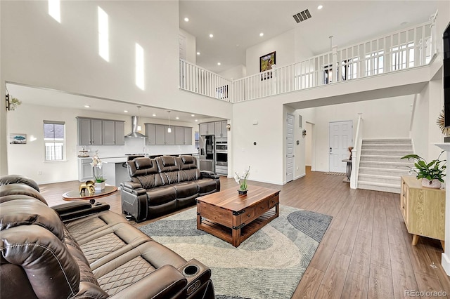 living room with light hardwood / wood-style floors and a high ceiling