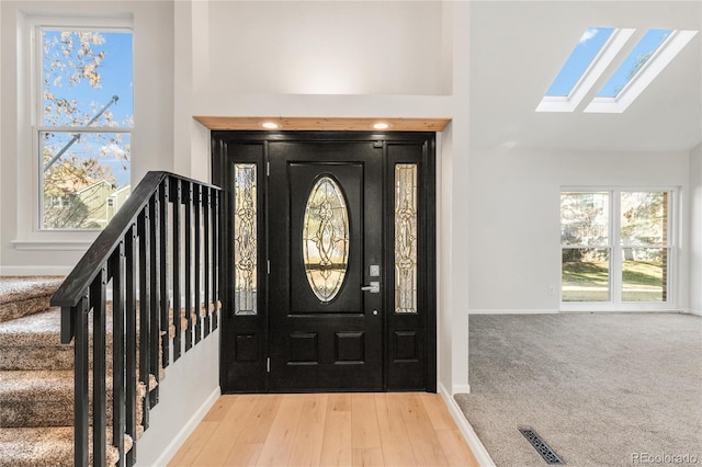 entryway featuring light colored carpet and high vaulted ceiling