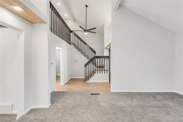 foyer with beamed ceiling, ceiling fan, high vaulted ceiling, and light carpet