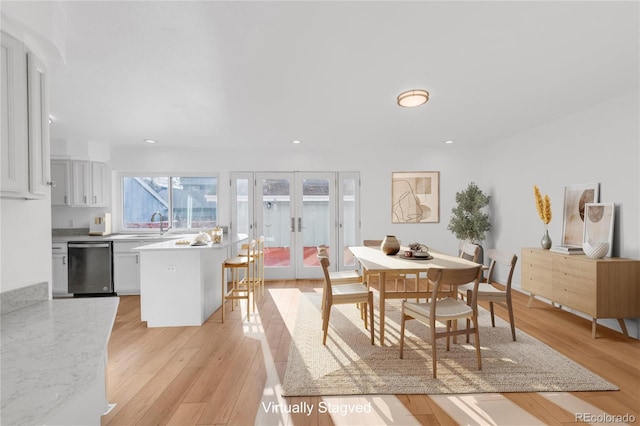 dining room with sink, light hardwood / wood-style flooring, and french doors