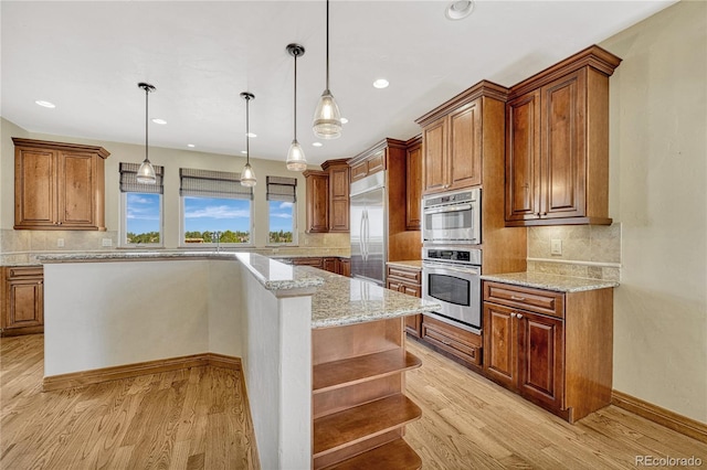 kitchen with stainless steel built in refrigerator, pendant lighting, tasteful backsplash, and light hardwood / wood-style flooring