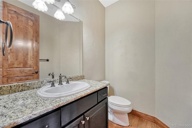 bathroom with hardwood / wood-style floors, vanity, and toilet