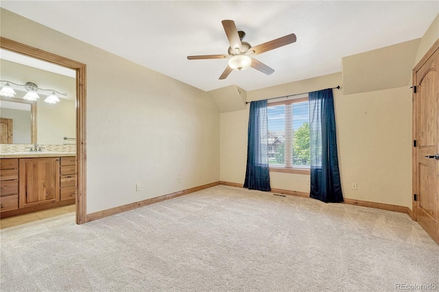 unfurnished bedroom featuring ceiling fan, light colored carpet, sink, and connected bathroom