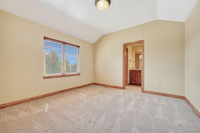 empty room with light carpet and vaulted ceiling