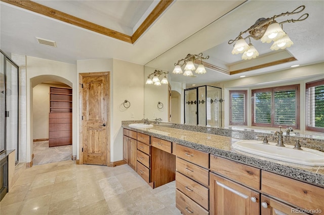 bathroom with an enclosed shower, vanity, a raised ceiling, and ornamental molding